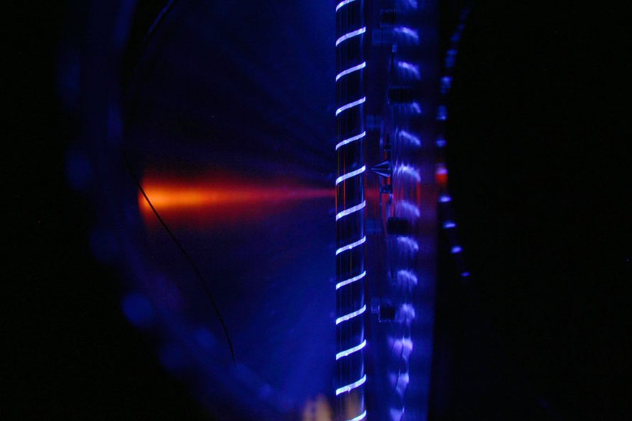 Laserfotolyysi reaktorissa. Putken reiästä poistuvat molekyylit napataan massaspektrometriin kuvassa näkyvästä kartiosta.