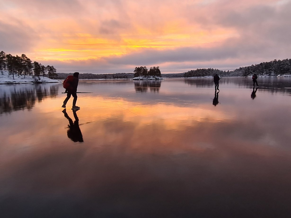 Aurinko väritti Inari-järven ja taivaan sen yllä marraskuussa 2020. Kuva: Mikael Holm