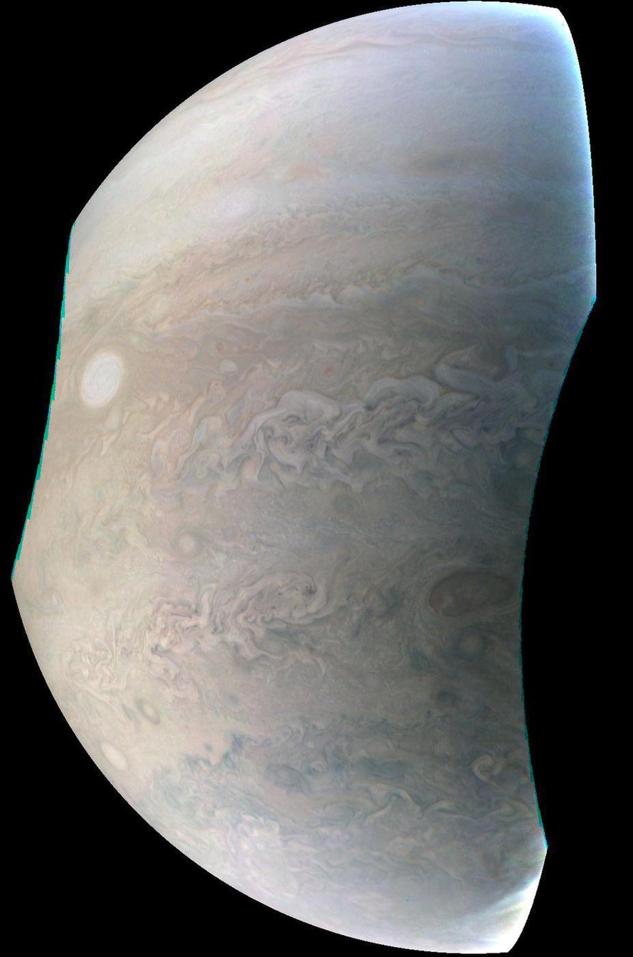 Jupiterin yksi vaalea helmi näkyy kuvassa soikeana vasemmalla. Se on valtava myrsky. Vastaavia laikkuja on Jupiterin pinnalla kahdeksan. Kuva: <span class="photographer">Nasa</span>