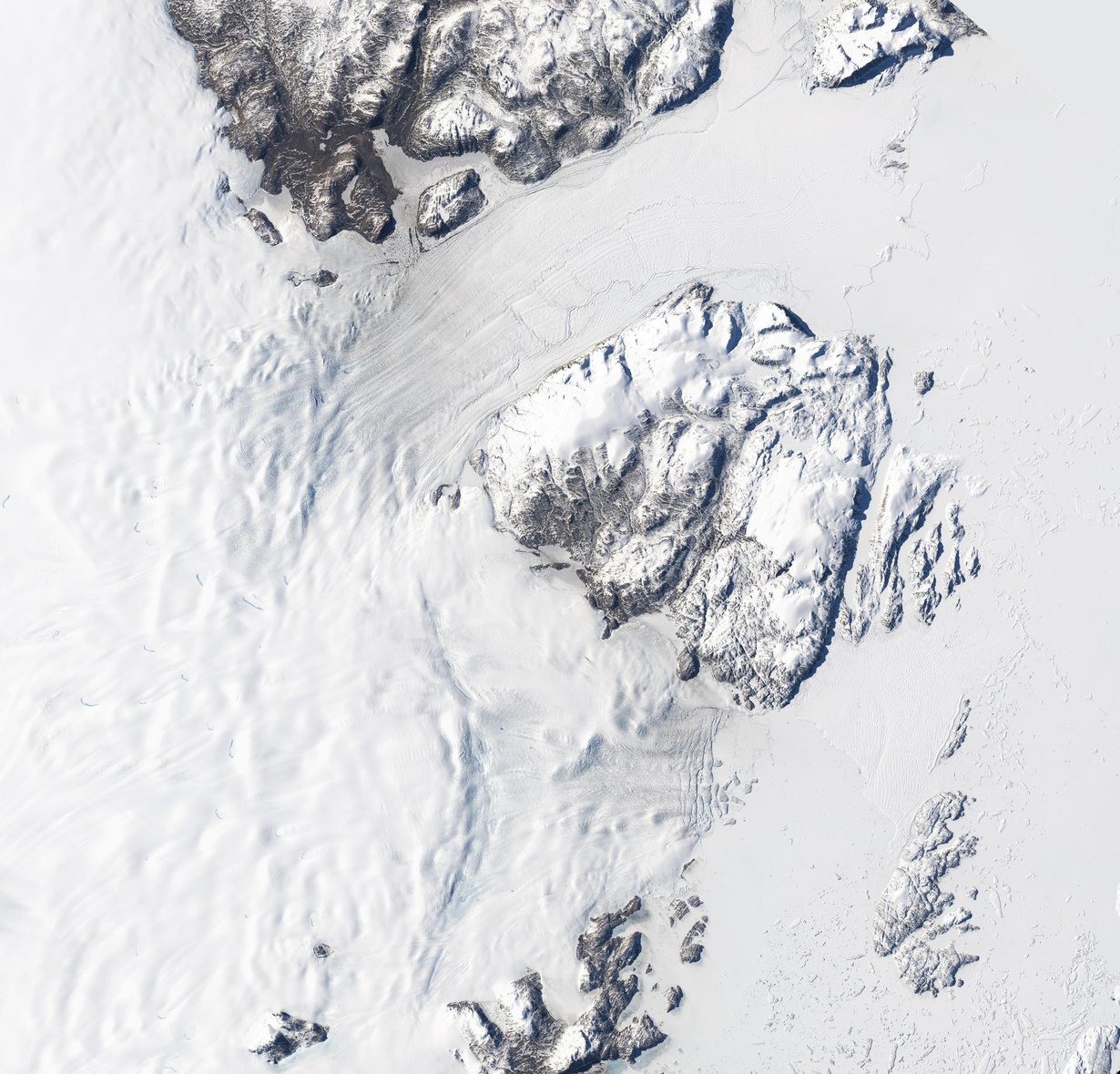 Nioghalvfjerdsfjorden ja Zachariæ Isstrøm vuotavat Atlanttiin. Jäävirroista ylempi kuuluu Nioghalvfjerdsfjordeniin, alempi Zachariæ Isstrømiin. Jäätiköiden vihollinen on sama kuin Etelämantereella: lämpenevä meri. Kuva: Nasa / USGS