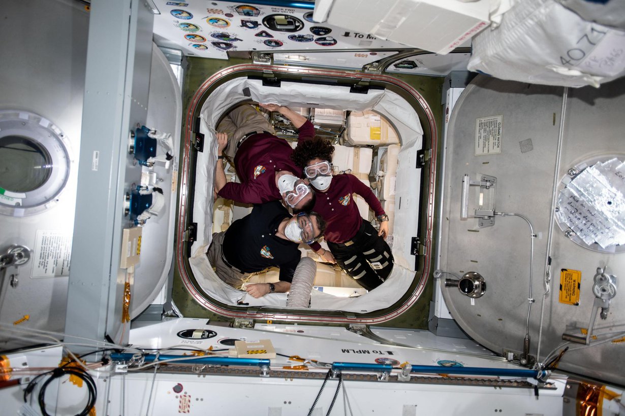 Kolme avaruuslentäjää kuvattiin rahtialus SpaceX Dragonin ruuman ovella 9. maaliskuuta. Jo silloin varauduttiin siihen, että Maasta olisi tullut vaarallisia hiukkasia viruksineen. Kuvassa Nasan Andrew Morgan (ylhäällä vasemmalla), Venäjän avaruusohjelman Oleg Skripotshka ja Nasan Jessica Meir (oikealla). Kuva: Nasa