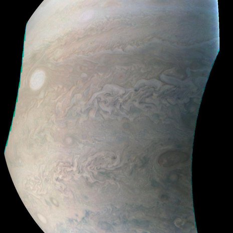 Jupiterin yksi vaalea helmi näkyy kuvassa soikeana vasemmalla. Se on valtava myrsky. Vastaavia laikkuja on Jupiterin pinnalla kahdeksan. Kuva: <span class="photographer">Nasa</span>