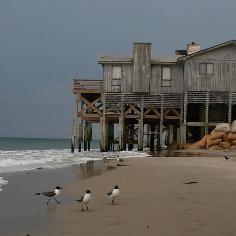 Merenpinnan nousu kuluttaa rantaa South Nags Headissa, Pohjois-Carolinan edustan Outer Banks -saarilla. Taloja on yritetty pelastaa jatkamalla tukipylväitä ja kasaamalla hiekkasäkkejä. Kuva: <span class="photographer">Pekka Mykkänen</span>