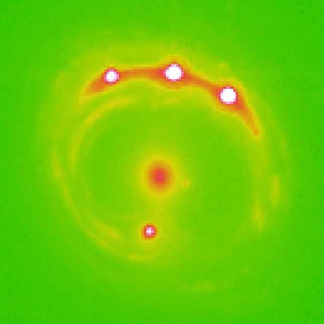 Gravitaatiolinssinä toimiva galaksi näkyy keskellä. Muut neljä kirkasta kohtaa ovat linssin suurentamia kvasaarin kuvajaisia. Kuva Ohio State University