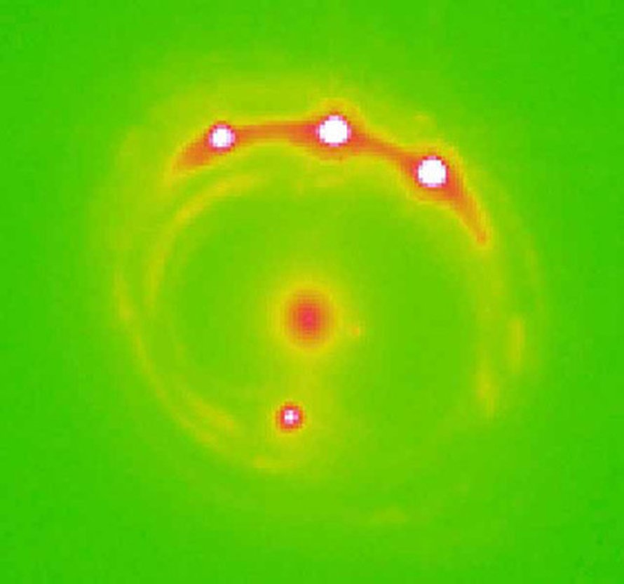 Gravitaatiolinssinä toimiva galaksi näkyy keskellä. Muut neljä kirkasta kohtaa ovat linssin suurentamia kvasaarin kuvajaisia. Kuva Ohio State University